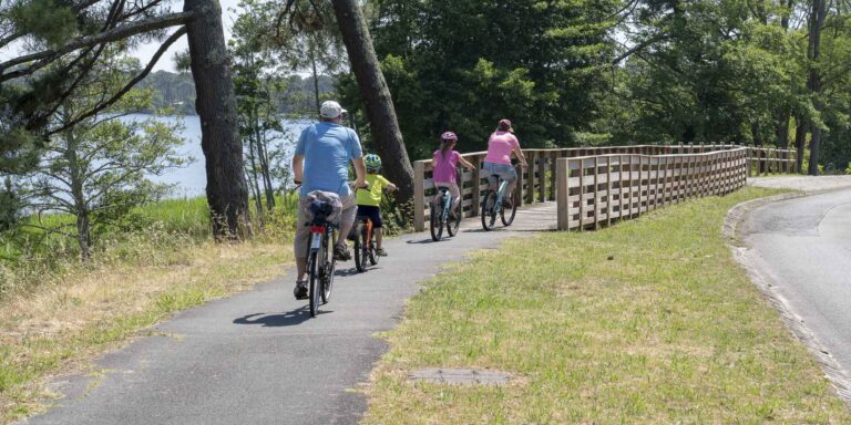 tourist family on bike ride in Lacanau lake bridge